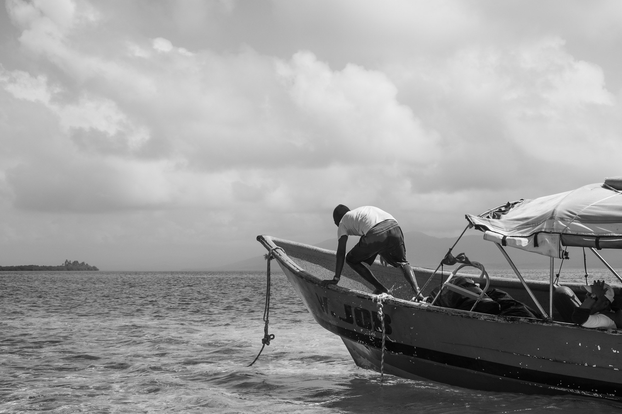 Hombre subiendo a una lancha frente a la costa de Guna Yala