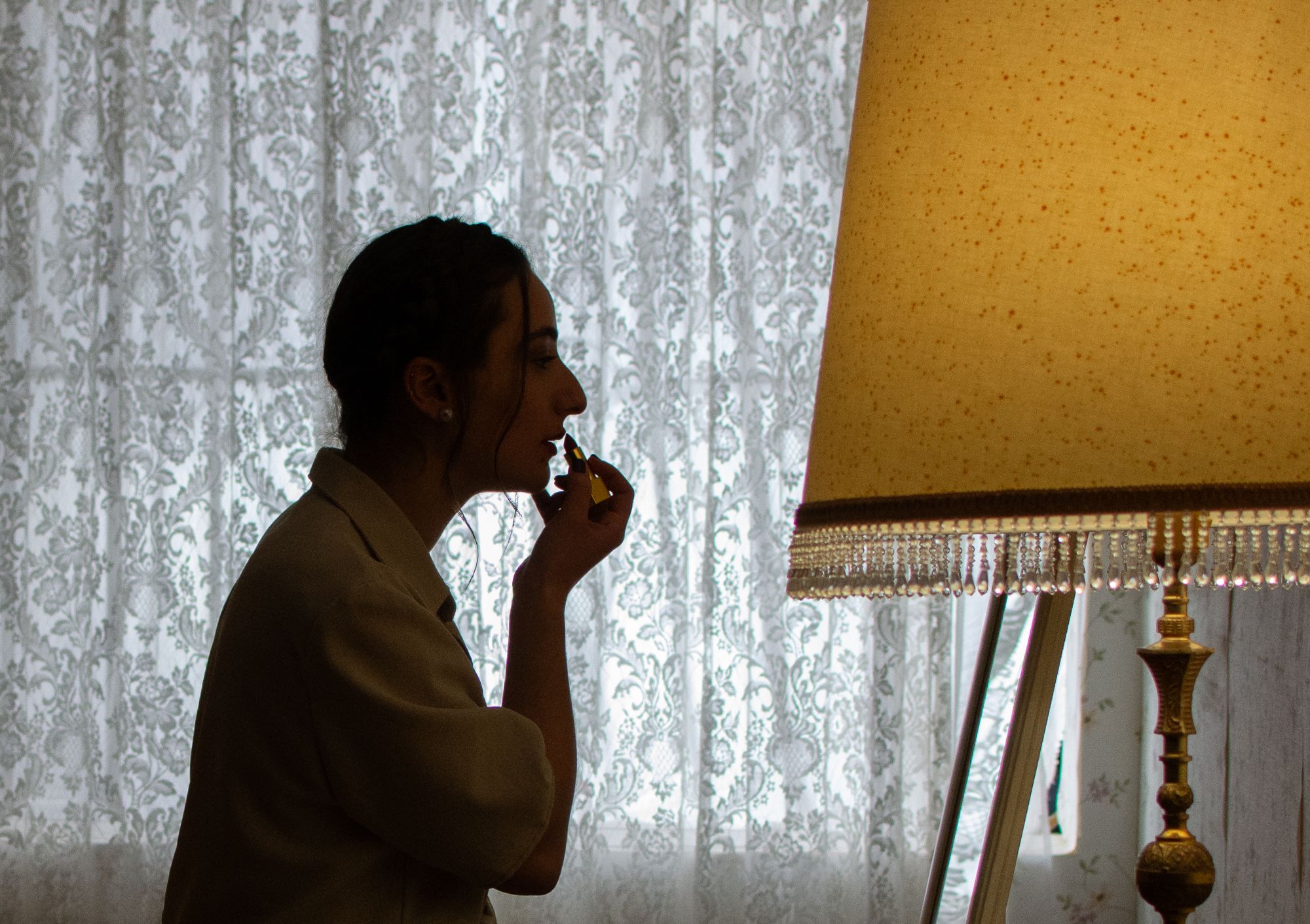 Fotograma de 'Mi nombre': la actriz aplicándose maquillaje a contraluz junto a la ventana
